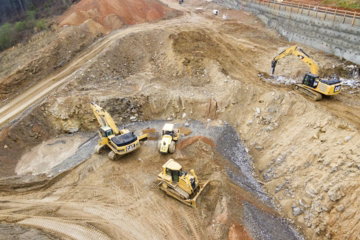 top view photography of four heavy equipment on quarry at daytime