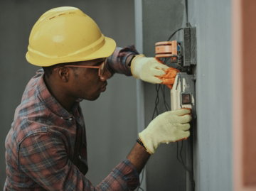 man in brown hat holding black and gray power tool