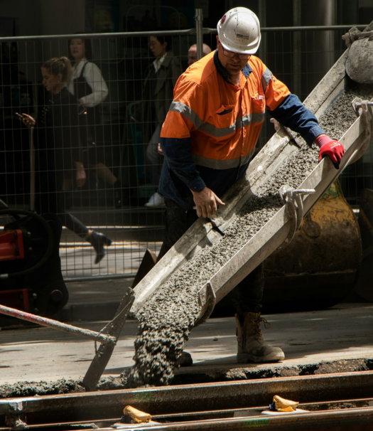 man pouring cements on road